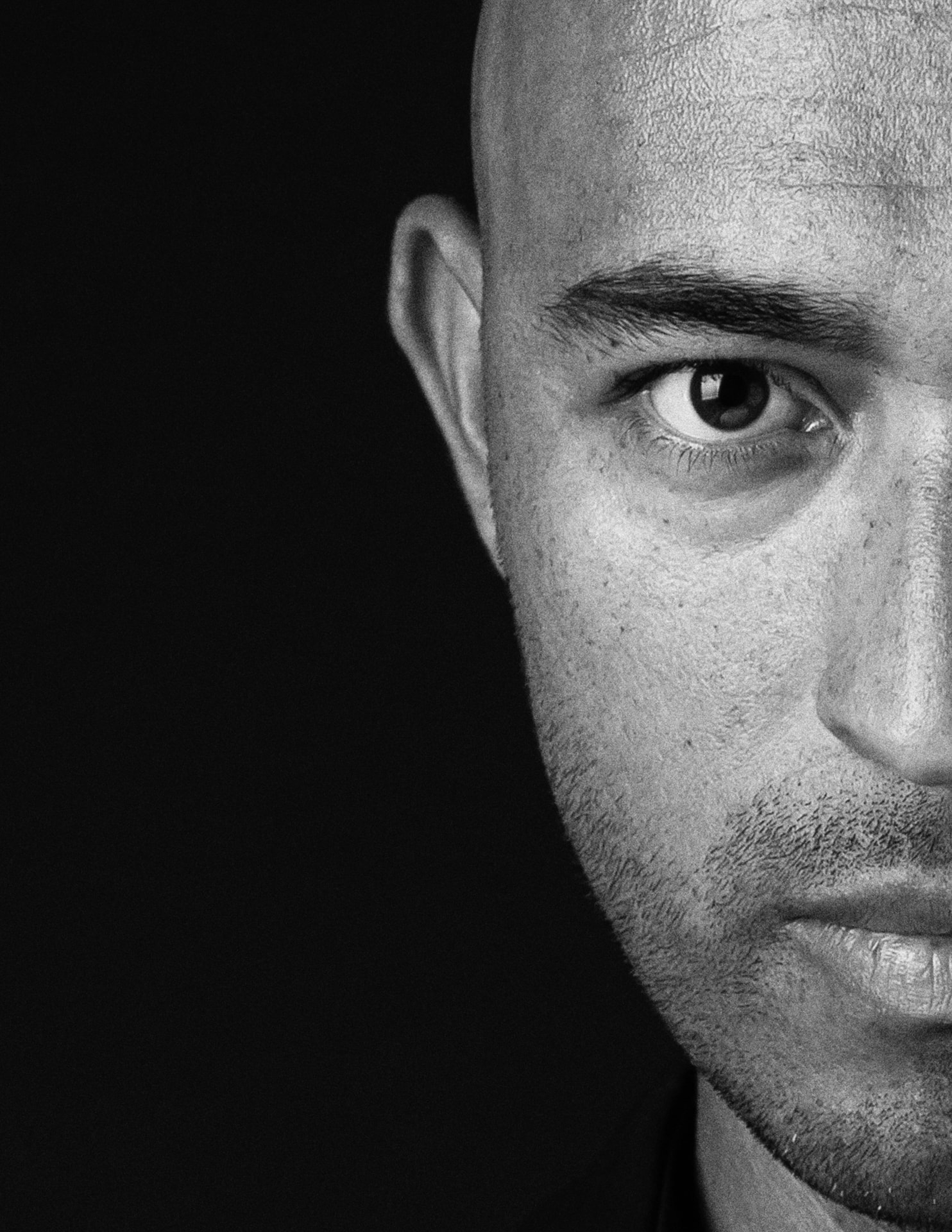 Close-up portrait of a bald man in dramatic light